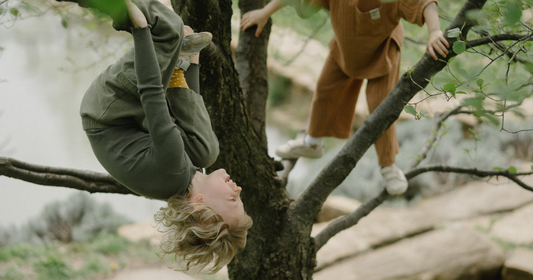 2 children climbing a tree