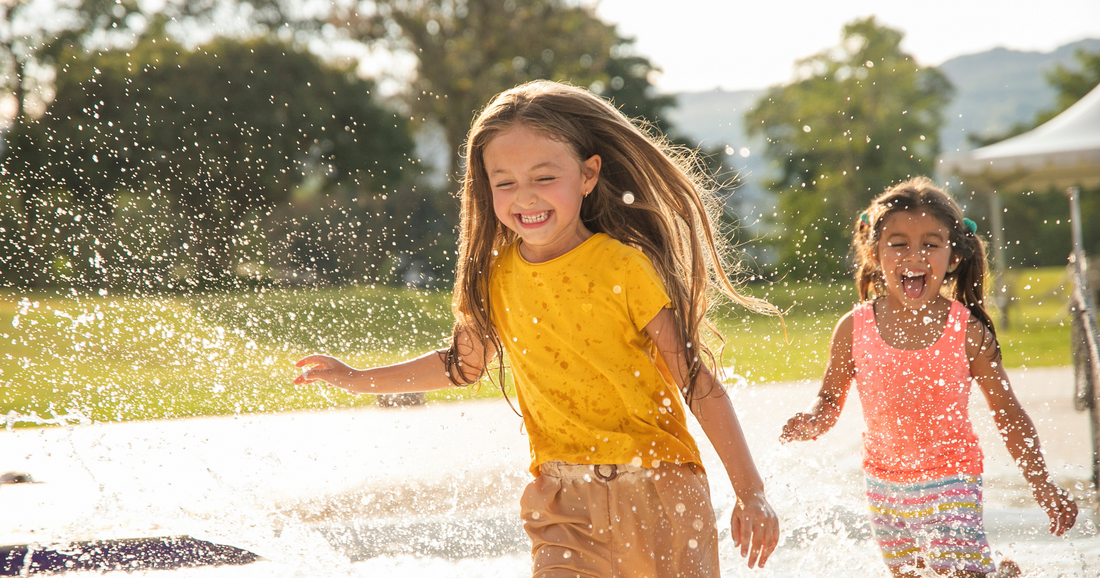 2 girls play in water in the summer