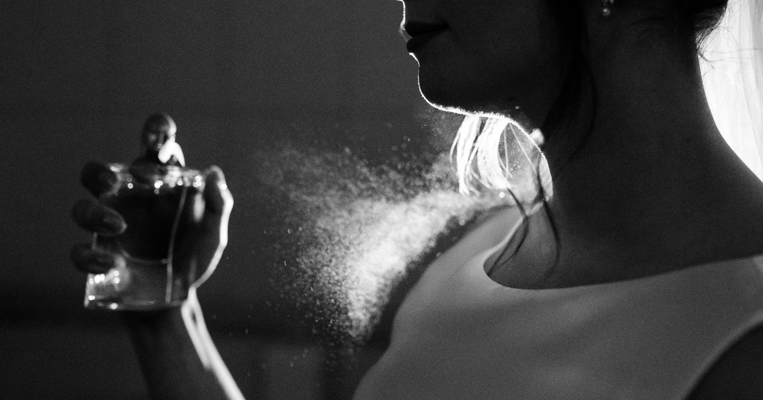 woman sprays perfume that unknowingly contains endocrine disrupting chemicals that disturb hormones