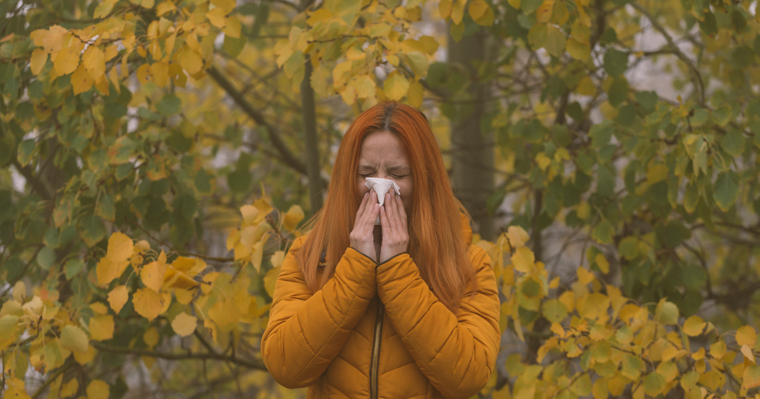 a woman blowing her nose shows signs of a cold, and indicator of a weak immune system